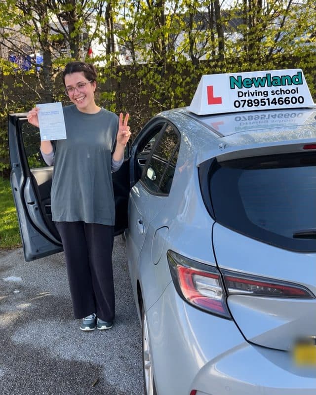 Pupil making a peace sign with her pass certificate